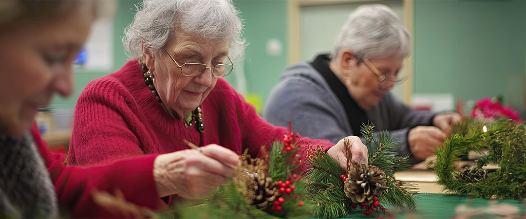 Seniors doing holiday activities together at a table.